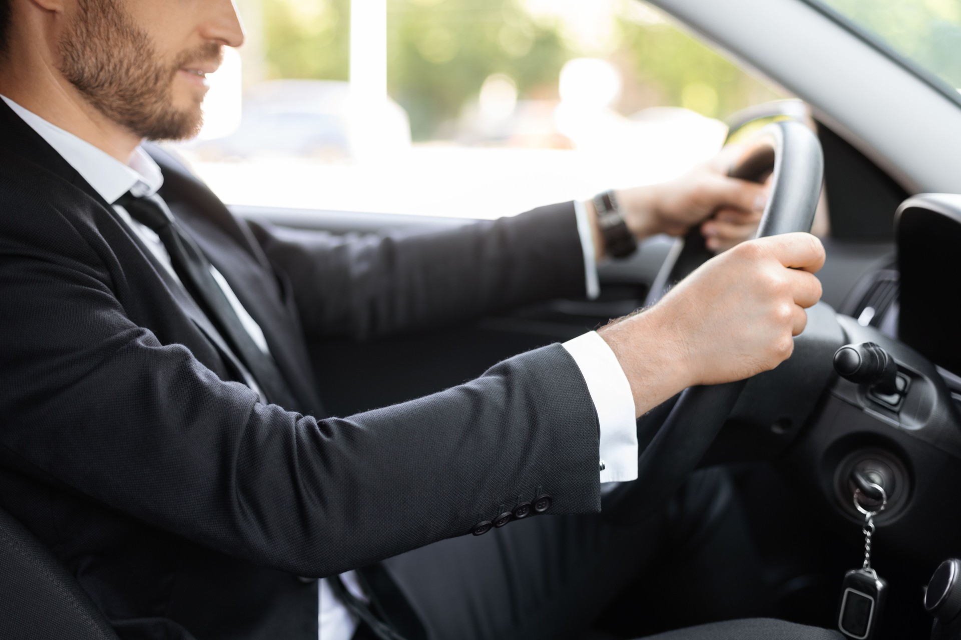 Unkenntlich erkennbarer Geschäftsmann hält Hände am Lenkrad, autofahren